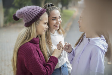Smiling teenage girls making a pinky promise - ZEF15603