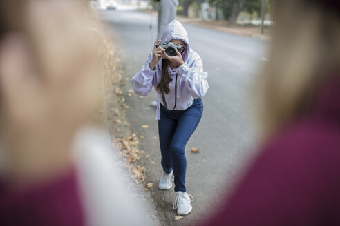 Teenager-Mädchen, das ein Foto von ihren Freunden auf der Straße macht - ZEF15604