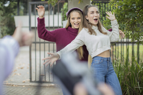 Teenage girl taking a picture of her happy friends outdoors stock photo