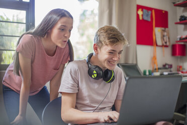 Teenager-Mädchen beobachtet Jungen bei der Benutzung eines Laptops - ZEF15622