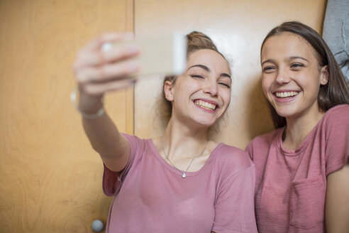 Porträt von zwei glücklichen Teenager-Mädchen, die ein Selfie machen - ZEF15639