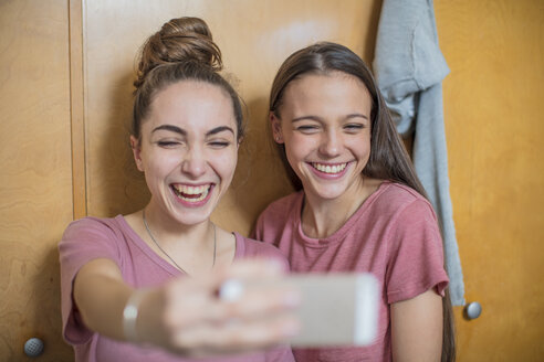 Porträt von zwei glücklichen Teenager-Mädchen, die ein Selfie machen - ZEF15640