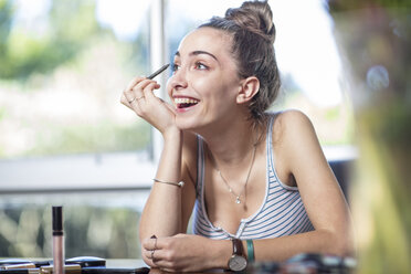 Happy teenage girl applying makeup - ZEF15651