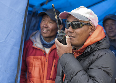 Nepal, Solo Khumbu, Everest, Sagamartha National Park, Mann spricht mit einem Walkie Talkie, lizenzfreies Stockfoto