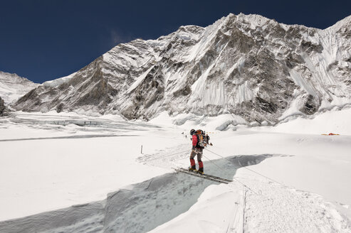 Nepal, Solo Khumbu, Everest, Sagamartha National Park, Bergsteiger überquert Eisfall auf einer Leiter - ALRF01269