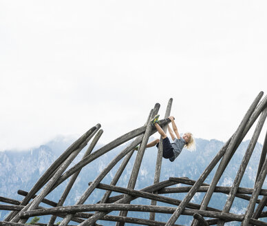 Junge klettert auf Holzkonstruktion auf Spielplatz, Füssen, Bayern, Deutschland - CUF23342