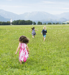 Rückansicht von Kindern, die auf einem Feld laufen, Füssen, Bayern, Deutschland - CUF23355