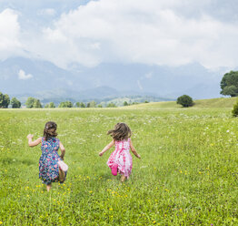 Rückansicht von Mädchen, die auf einem Feld laufen, Füssen, Bayern, Deutschland - CUF23359