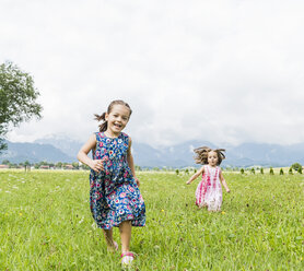Girls running in field, Fuessen, Bavaria, Germany - CUF23360