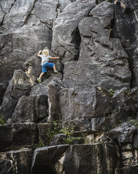 Rückansicht eines Jungen beim Klettern an einer Felswand - CUF23369