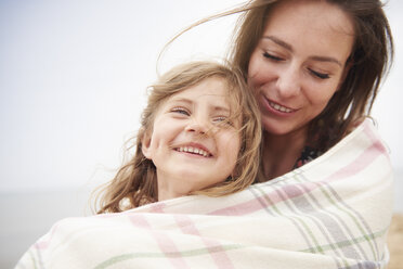 Happy mother and daughter wrapped in blanket - CUF23422