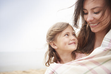 Happy mother and daughter wrapped in blanket - CUF23432