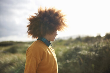 Frau mit Afro-Haar auf grasbewachsener Düne - CUF23543