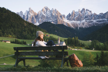 Frau, die sich auf einer Parkbank ausruht, Santa Maddalena, Dolomiten, Val di Funes (Fünser Tal), Südtirol, Italien - CUF23562