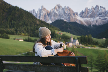 Frau, die sich auf einer Parkbank ausruht, Santa Maddalena, Dolomiten, Val di Funes (Fünser Tal), Südtirol, Italien - CUF23563