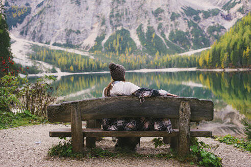 Woman relaxing on park bench, Lago di Braies, Dolomite Alps, Val di Braies, South Tyrol, Italy - CUF23566