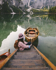 Woman relaxing on pier, Lago di Braies, Dolomite Alps, Val di Braies, South Tyrol, Italy - CUF23569