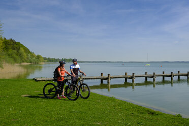 Germany, Upper Bavaria, Schalchen, Chiemgau, cyclists at Chiemsee - LBF01951