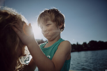 Mother and playful son at a lake - JLOF00003