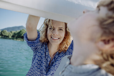 Smiling mother looking at son on a sailing boat - JLOF00017