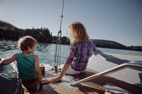 Mother and son sitting on deck of a sailing boat - JLOF00022