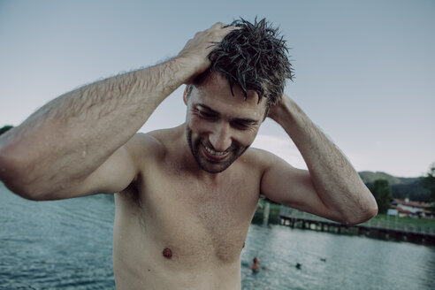 Smiling man at swimming lake - JLOF00055