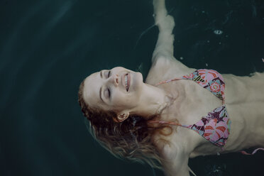 Carefree woman swimming in water - JLOF00057