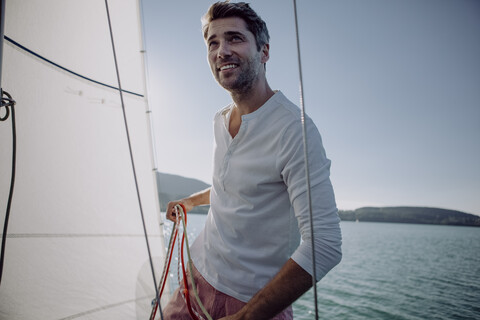 Lächelnder Mann auf einem Segelboot, lizenzfreies Stockfoto