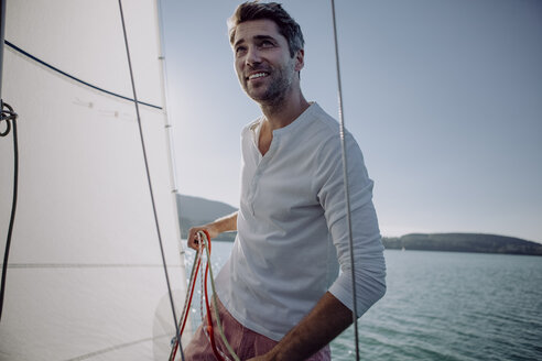 Lächelnder Mann auf einem Segelboot - JLOF00072