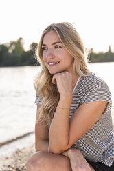 Portrait of blond woman at riverside in the evening - UUF14024