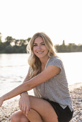 Portrait of blond woman at riverside in the evening - UUF14025