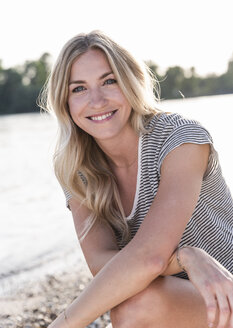 Portrait of blond woman at riverside in the evening - UUF14026