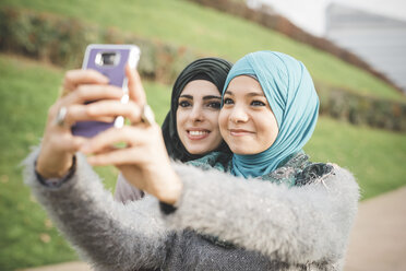 Zwei Freundinnen im Park machen ein Smartphone-Selfie - CUF23615