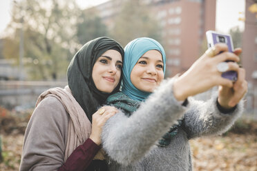 Zwei Freundinnen im Park posieren für ein Smartphone-Selfie - CUF23616