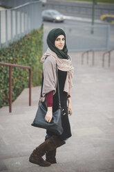 Porträt einer jungen Frau mit Hidschab auf einer Treppe - CUF23633
