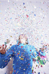 Studio shot of young woman and explosion of confetti - CUF23644