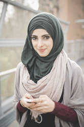Porträt einer jungen Frau mit Hidschab auf einer Fußgängerbrücke - CUF23662