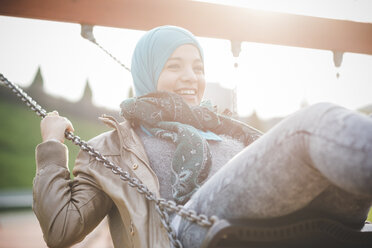 Young woman swinging on playground swing - CUF23665