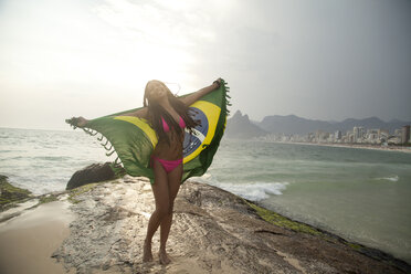 Junge Frau hält brasilianische Flagge hoch, Strand von Ipanema, Rio De Janeiro, Brasilien - CUF23689