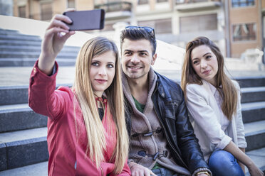 Junge Frau macht Smartphone-Selfie mit Freunden auf einer Treppe, Cagliari, Sardinien, Italien - CUF23698