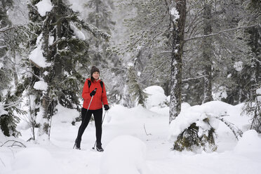 Junge Frau beim Nordic Walking durch verschneite Wälder, Posio, Lappland, Finnland - CUF23734