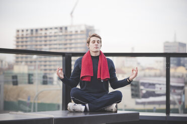 Junger Mann übt Lotus-Yoga-Position auf dem Dach der Stadt - CUF23772