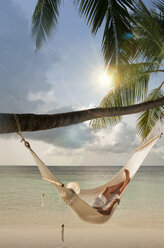Mid adult woman relaxing in hammock, Ari Atoll, Maldives - CUF23870