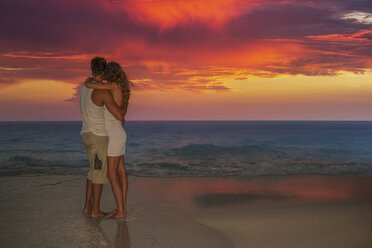 Couple standing on beach at sunset, Ari Atoll, Maldives - CUF23874