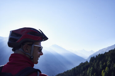 Mountain biker wearing helmet in mountains, Valais, Switzerland - CUF23877