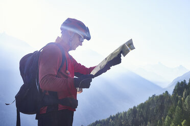 Mountain biker holding map, Valais, Switzerland - CUF23879