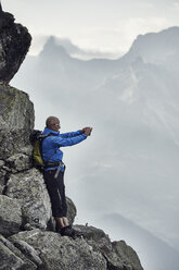 Älterer Mann auf Felsen beim Fotografieren, Wallis, Schweiz - CUF23892