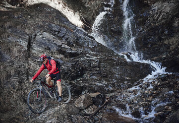 Mountainbiker fährt über Felsen - CUF23905