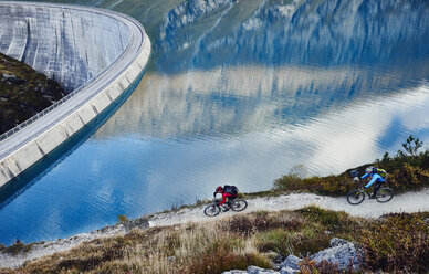 Mountainbiker am Stausee, Wallis, Schweiz - CUF23914