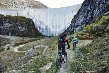 Mountainbiker am Staudamm, Wallis, Schweiz - CUF23915
